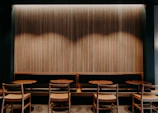 A neatly arranged seating area with warm wooden furniture and ambient lighting