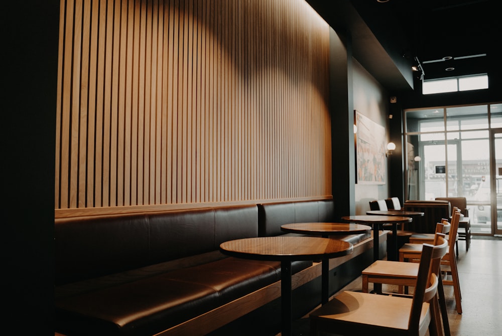 round brown wooden tables beside black leather sofa