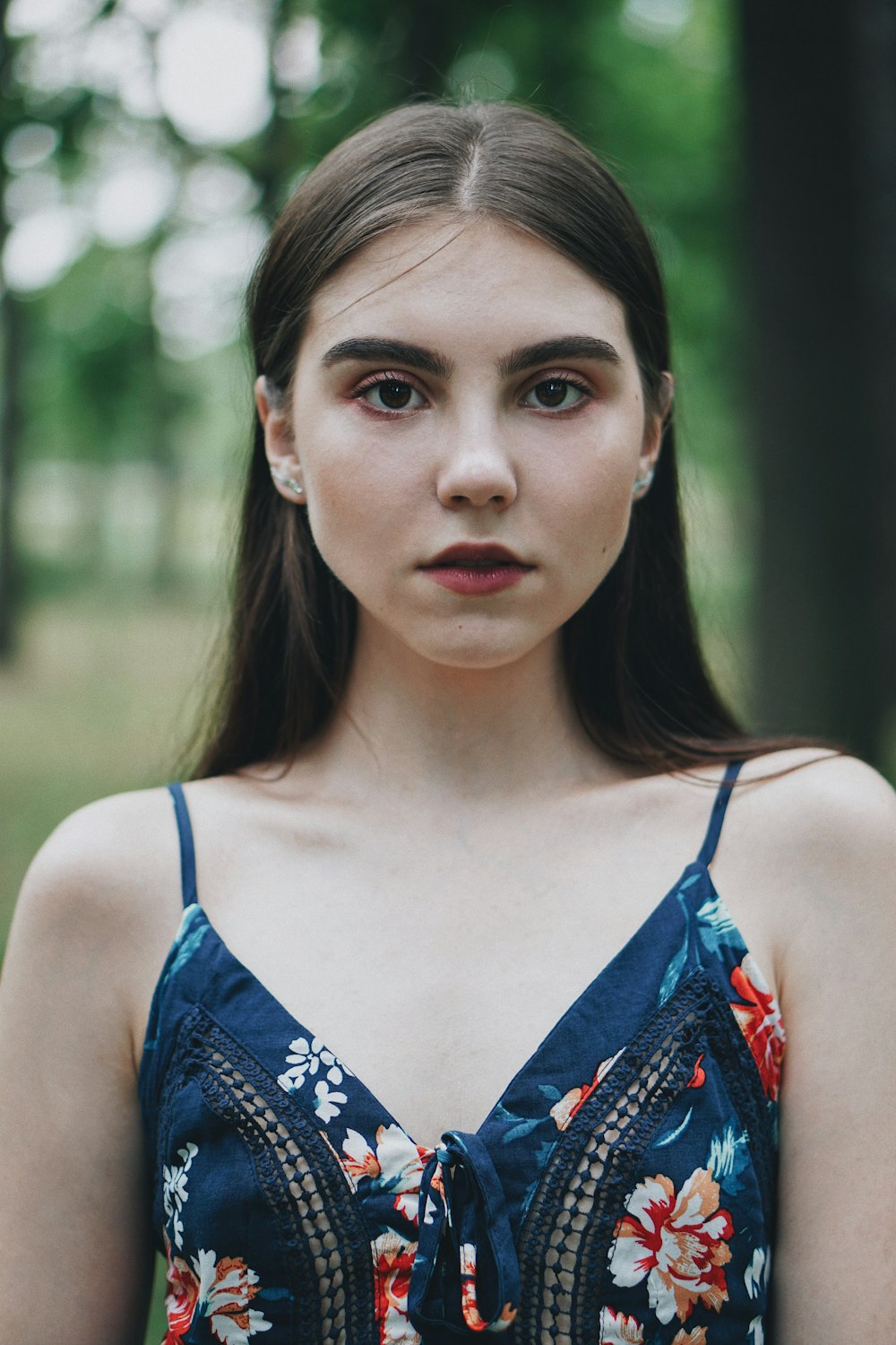 a woman in a blue dress standing in a forest