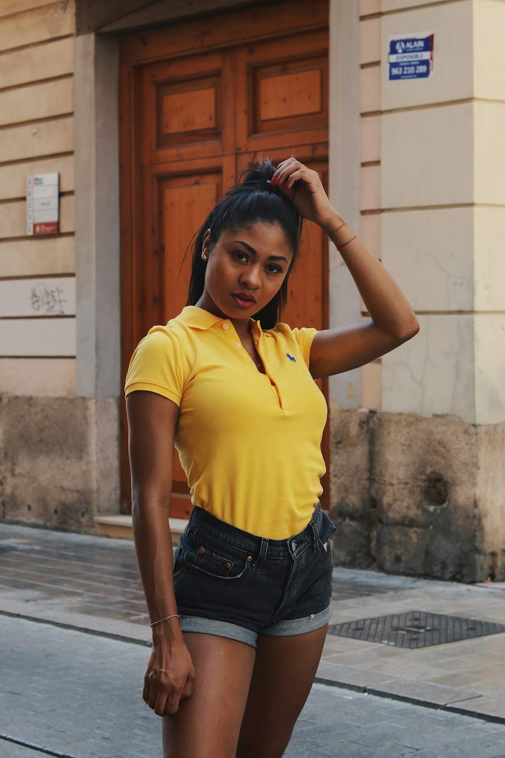 a woman in a yellow shirt is posing for a picture