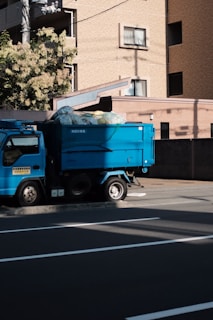 blue utility truck parked in front of building
