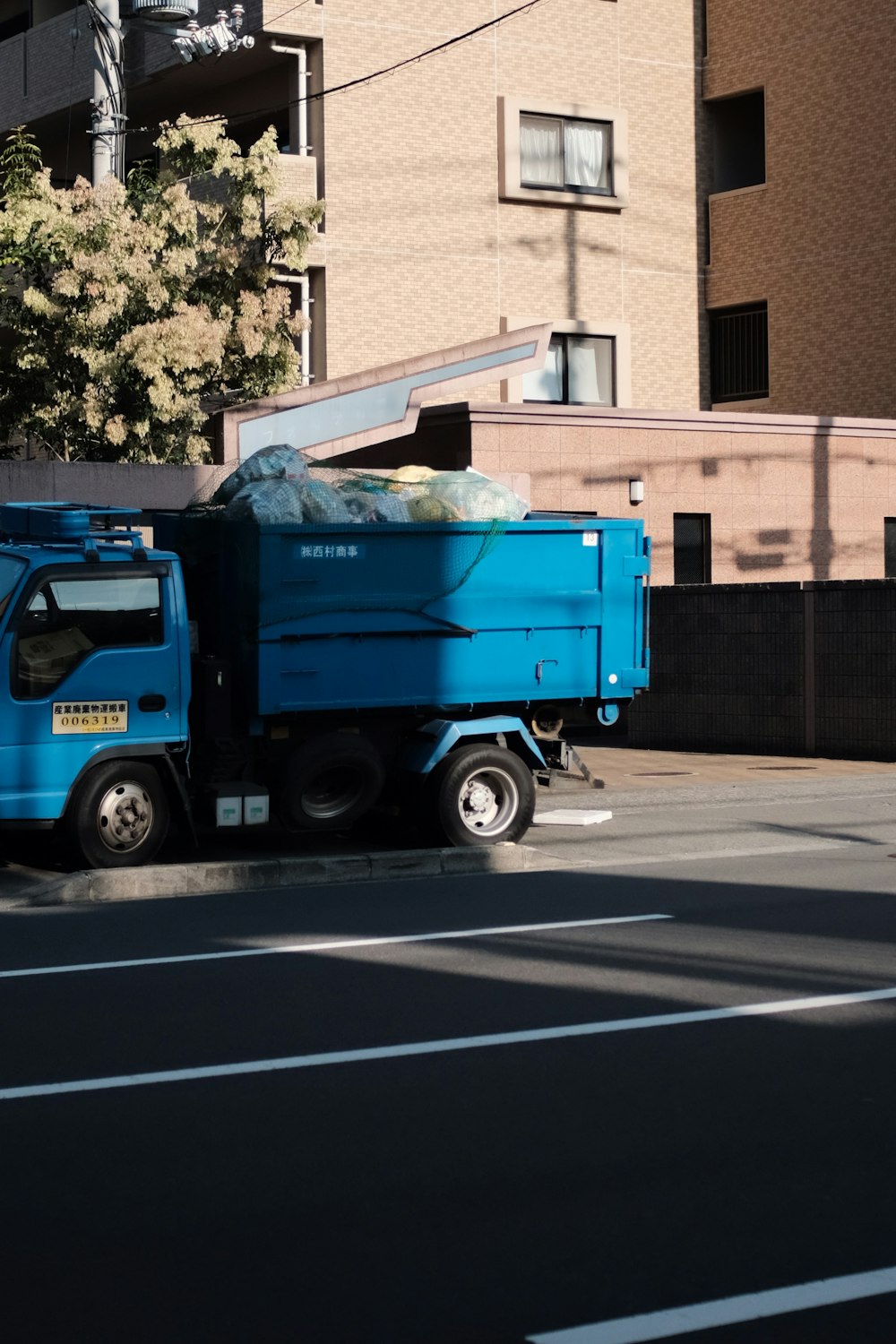 Camión utilitario azul estacionado frente al edificio