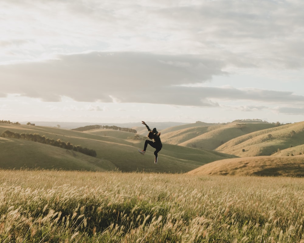 person jumping on grass field