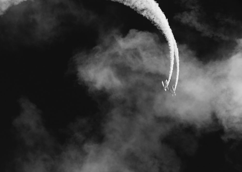 Une photo en noir et blanc d’une traînée de condensation dans le ciel