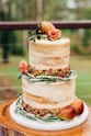 a three tiered cake with figs on top of it
