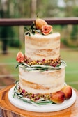a three tiered cake with figs on top of it