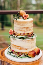 a three tiered cake with figs on top of it