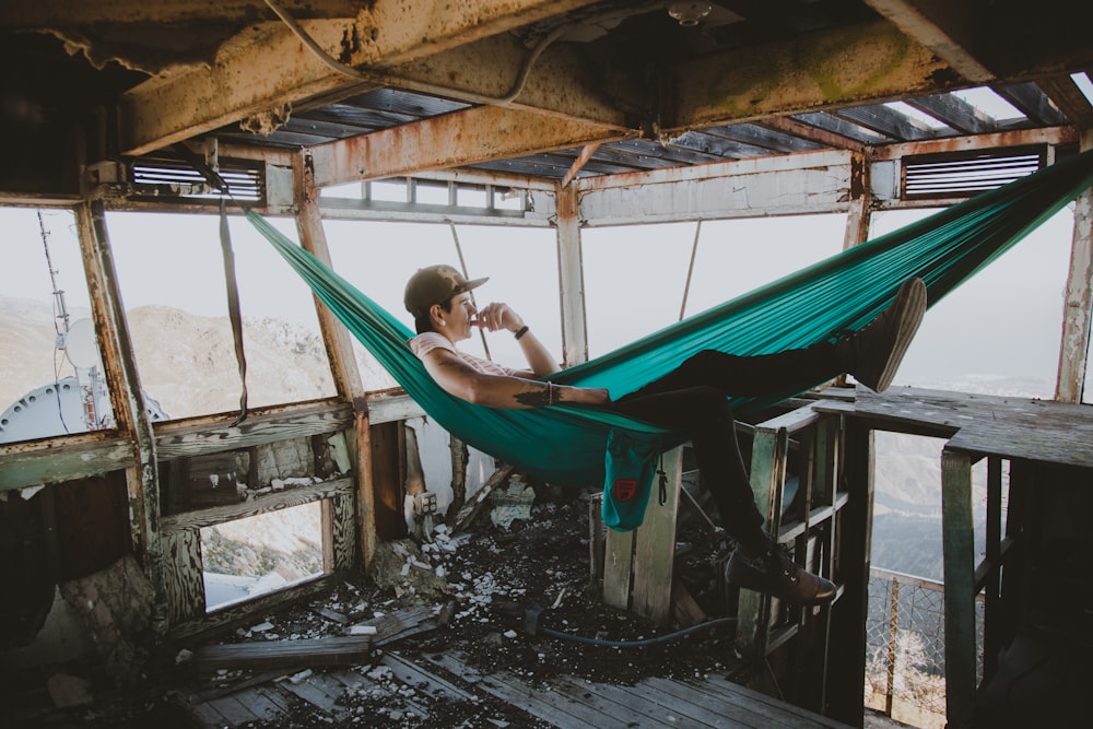 a man sitting in a hammock on top of a building