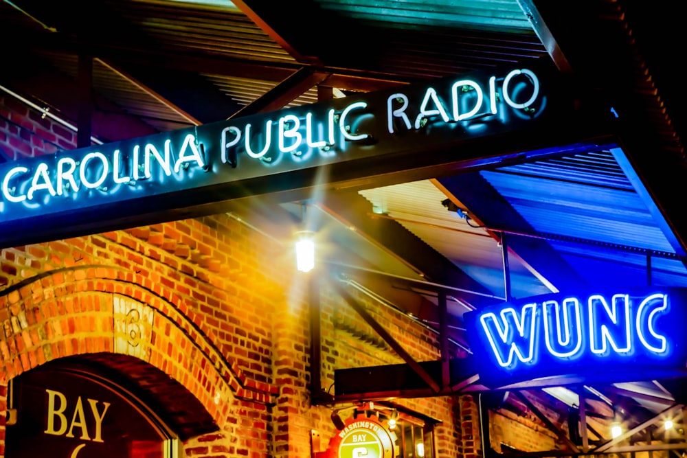 a brick building with a neon sign above it