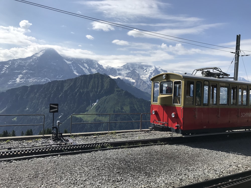 red and gray train near mountain at daytime