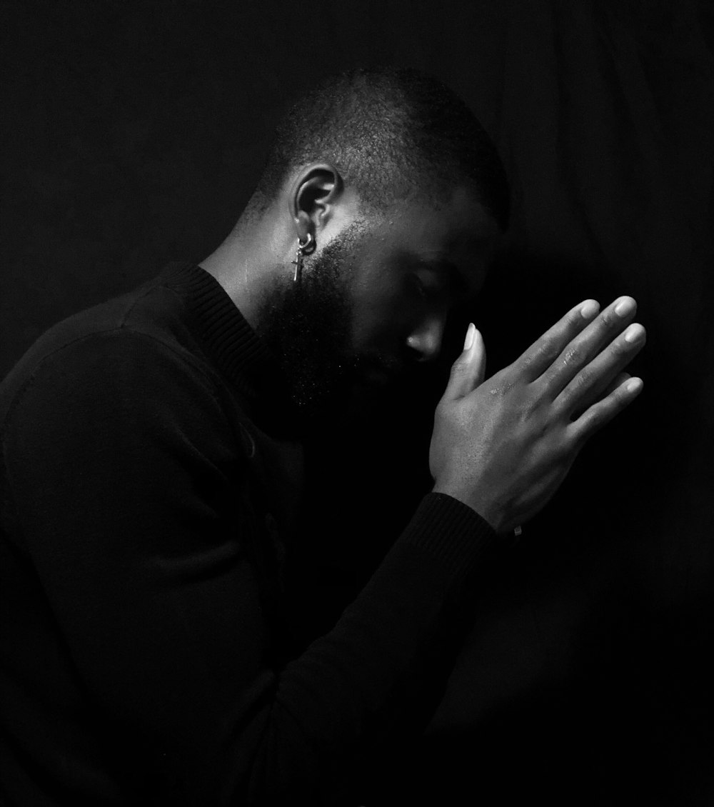 Ein Mann mit den Händen im Gebet gefaltet