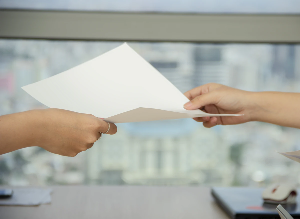 Tangan menyerahkan selembar kertas kepada orang lain