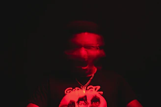a man in a dark room with a red light