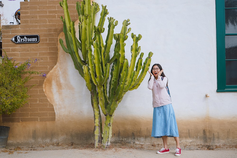 a woman talking on a cell phone next to a cactus