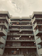 Modern urban apartment building with balconies overlooking a bustling city street.