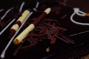 Close-up of a glossy chocolate entremet with delicate gold leaf accents.