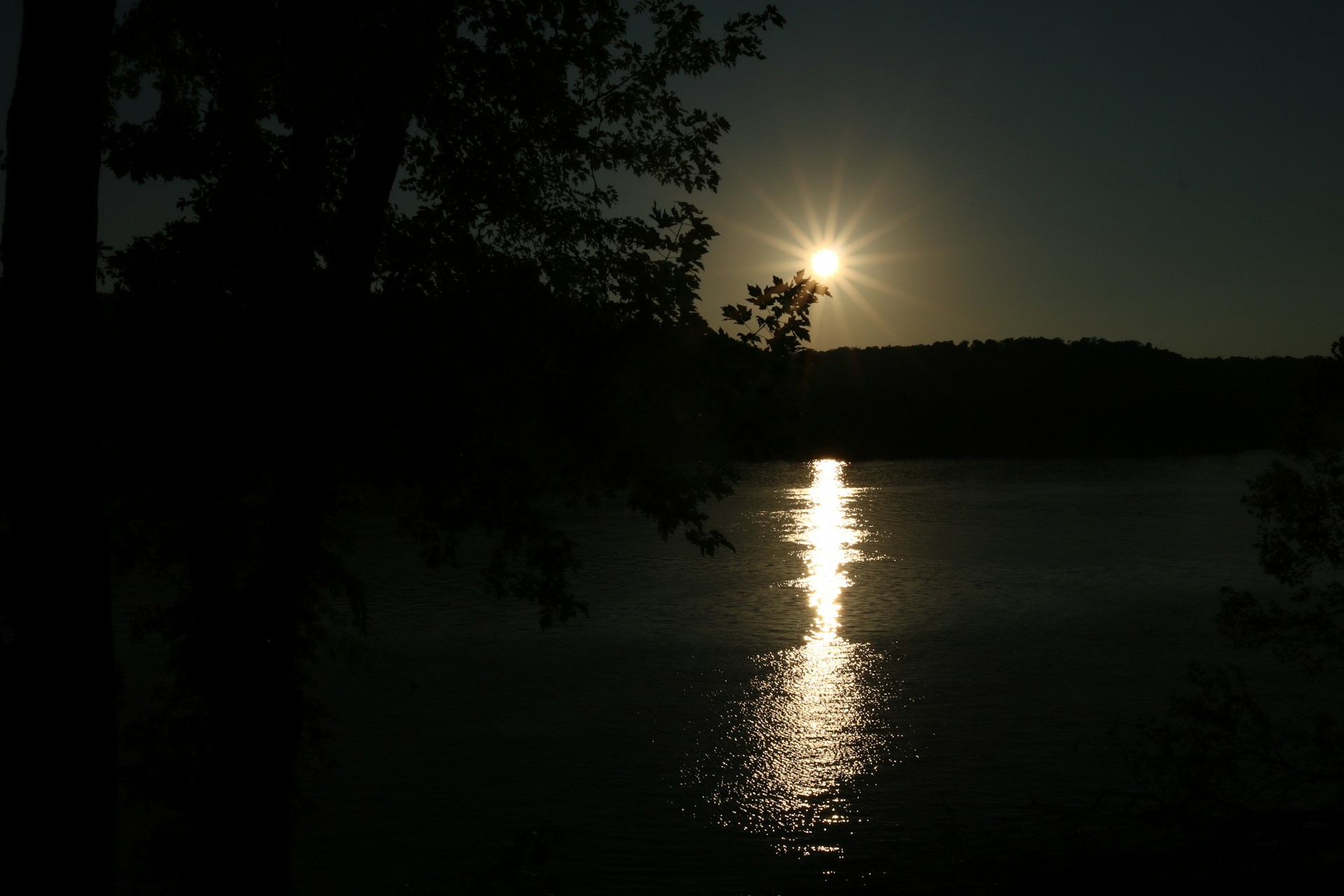 A serene sunset over a tranquil lake, symbolizing peace and remembrance.