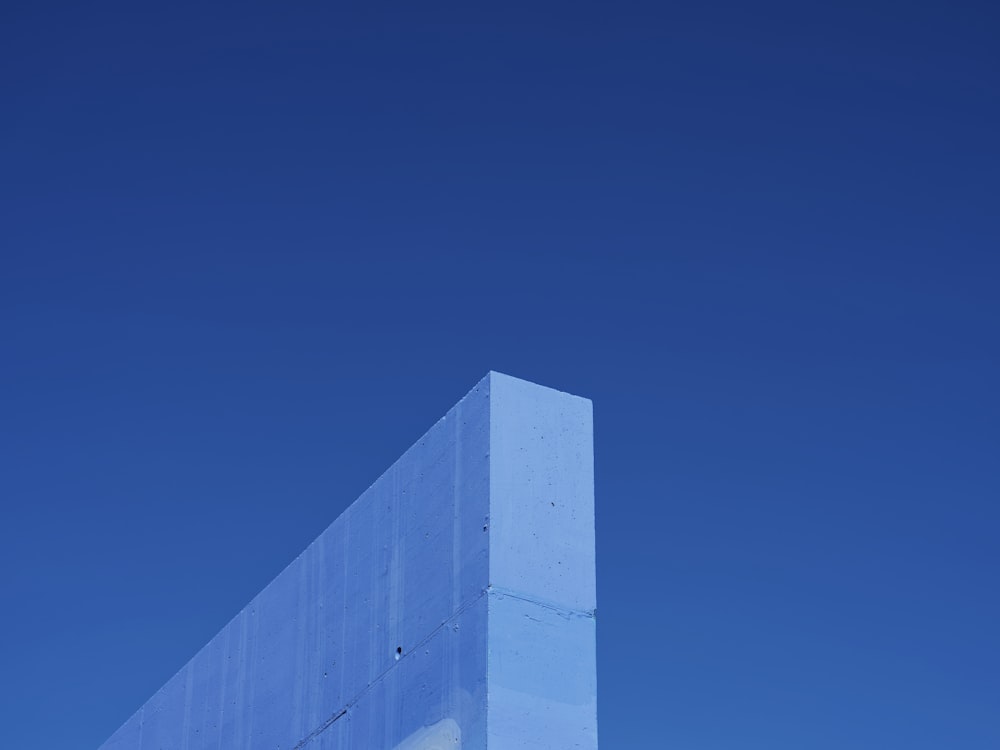 Un edificio alto y blanco sentado bajo un cielo azul