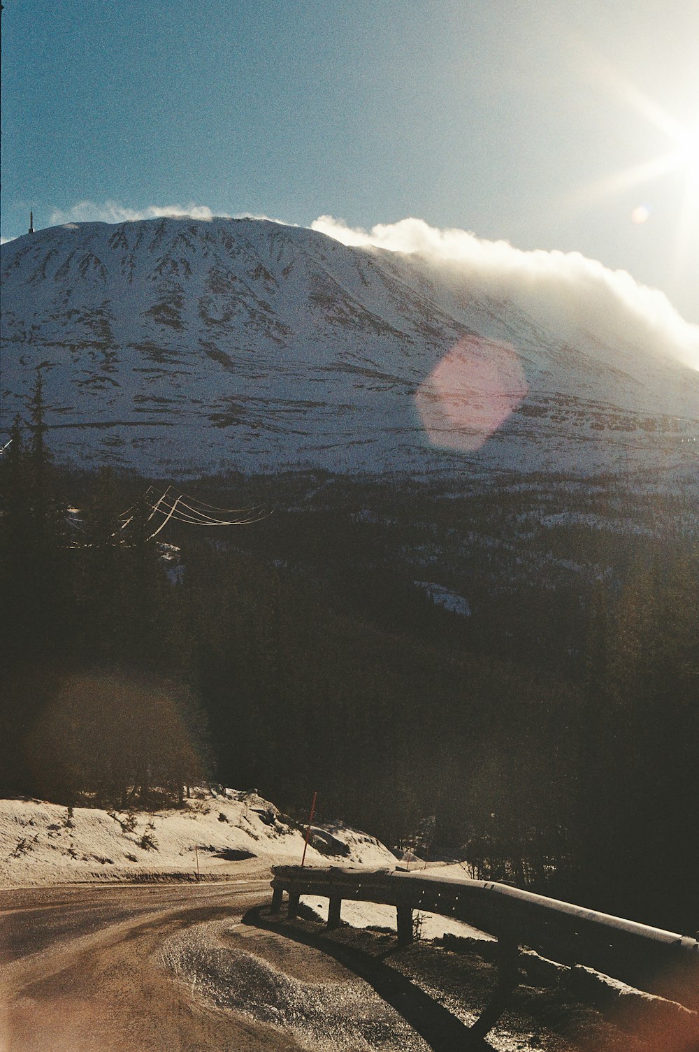 a snow covered mountain with a bridge in the foreground