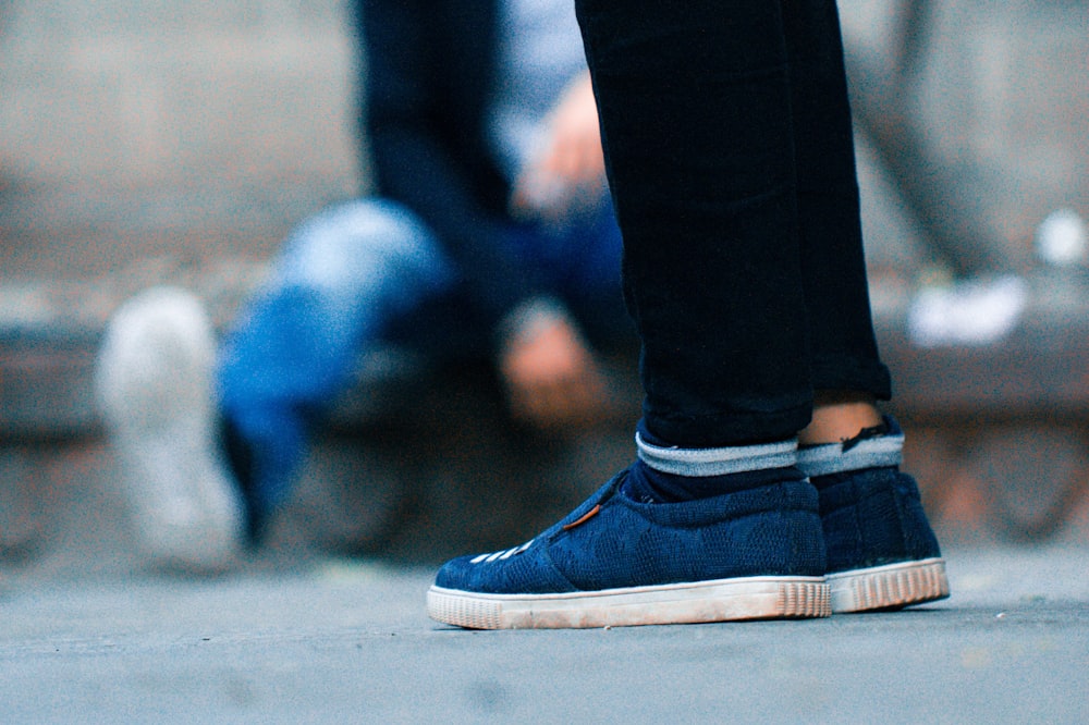 person wearing blue-and-white low-top sneakers