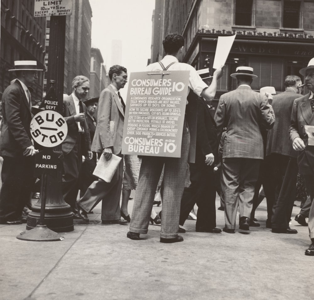 grayscale photo of men walking on roadside