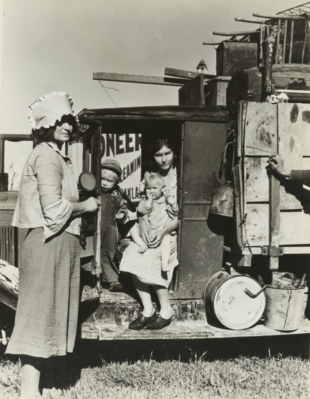 grayscale photo of woman sitting on vehicle