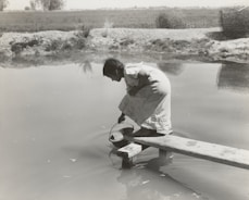 Technician collecting water sample from a rural well