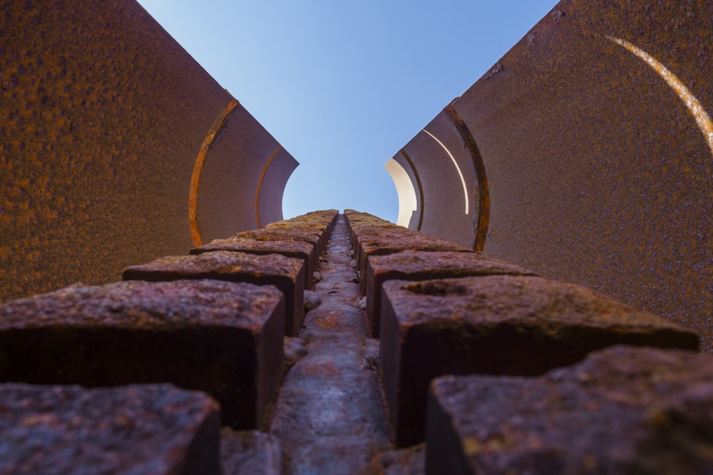 way between walls under clear blue sky