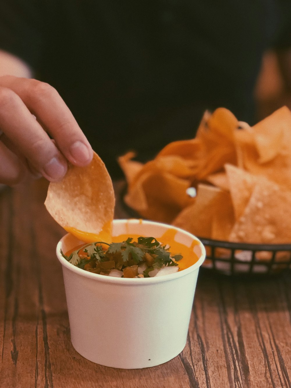 person holding chip pointing on sauce