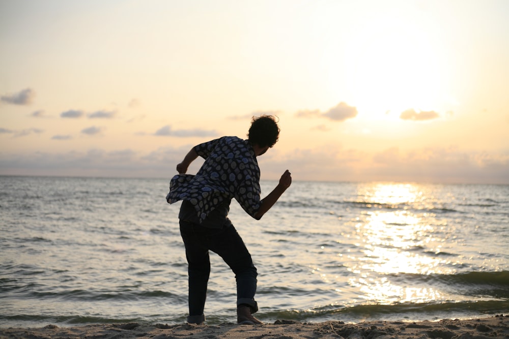 man about to throw stone on sea