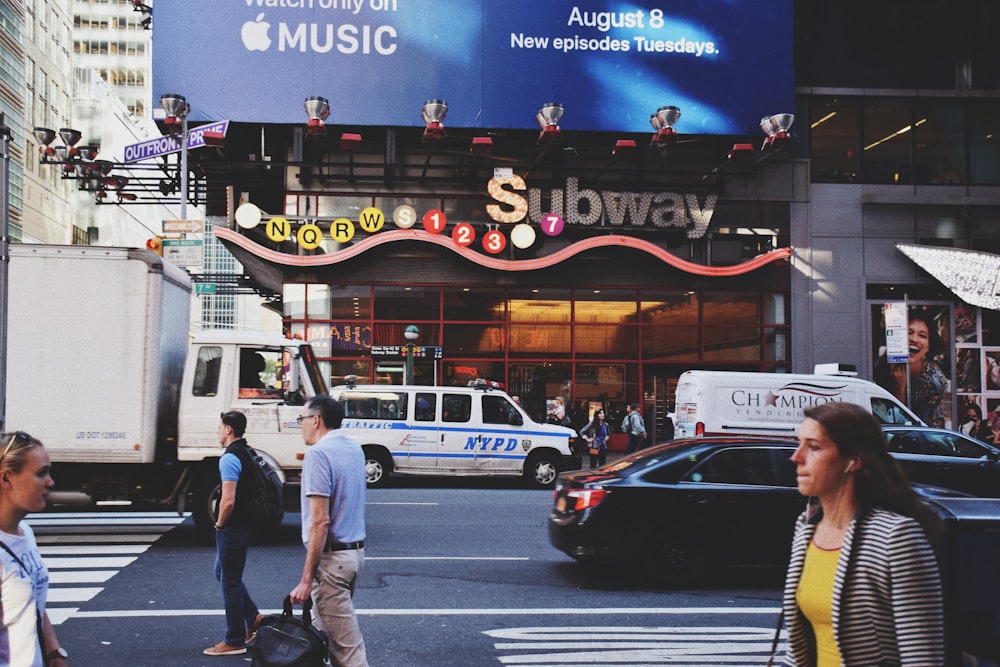 people walking on road in front of Subway building