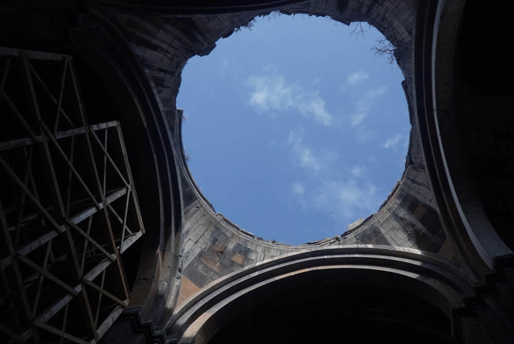 low-angle photography of concrete building under blue and white skies