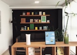 black iPad near lucky bamboo in vase on brown wooden shelf inside room