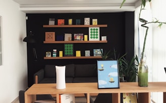 black iPad near lucky bamboo in vase on brown wooden shelf inside room