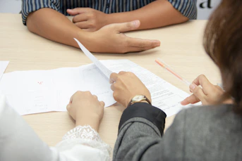 two people reviewing documents at meeting table