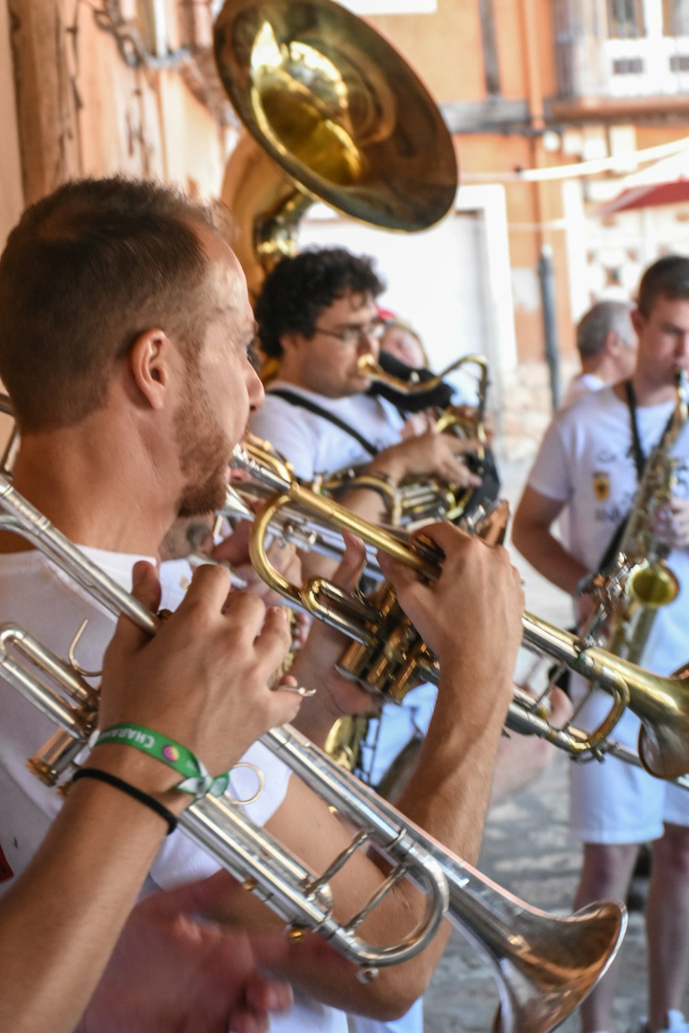 male band playing brass wind instrument outdoors