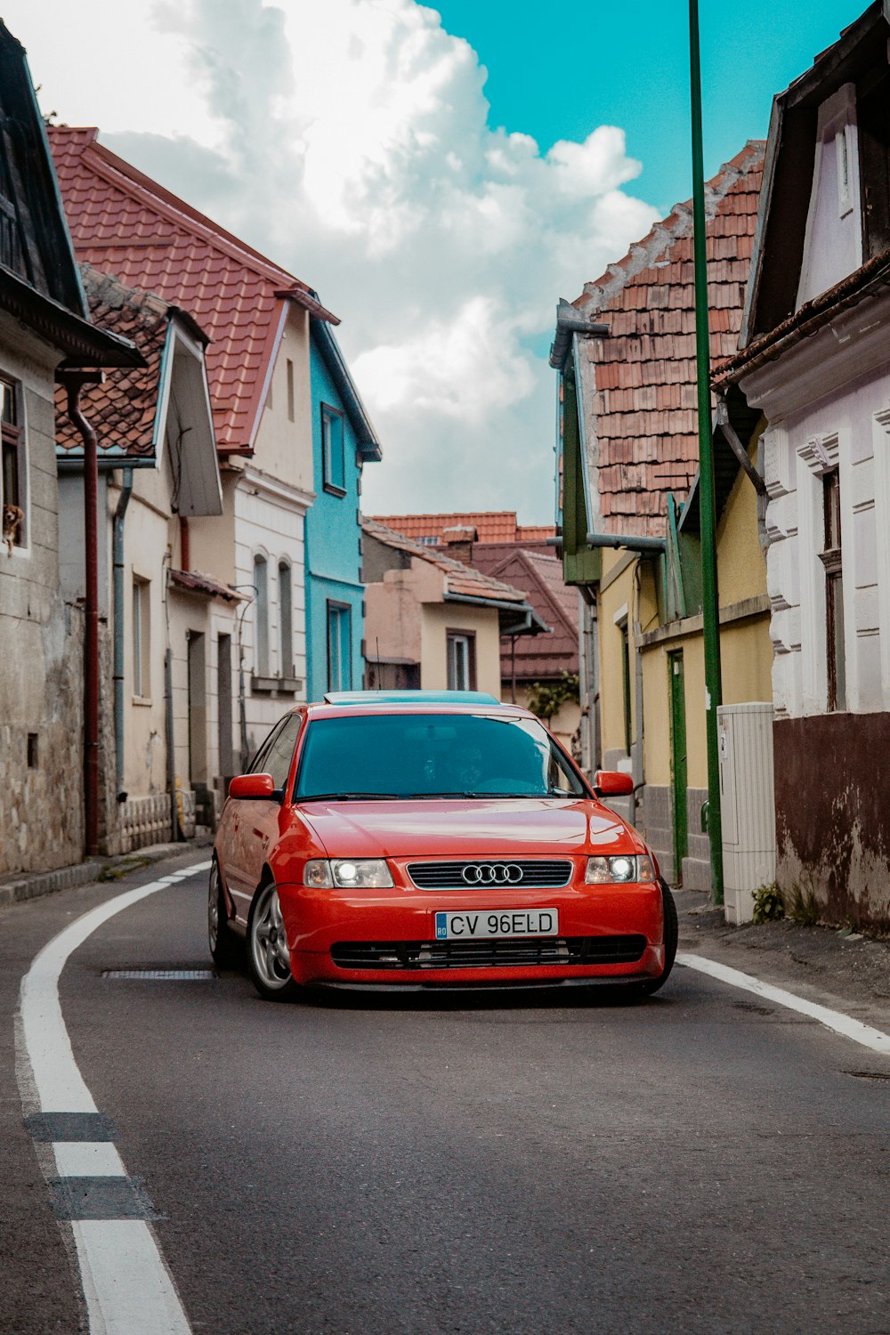 Audi RS2 rojo en la carretera cerca de las casas