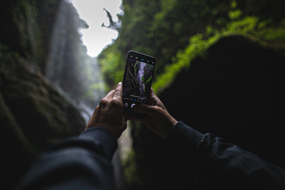 person taking photo with black smartphone