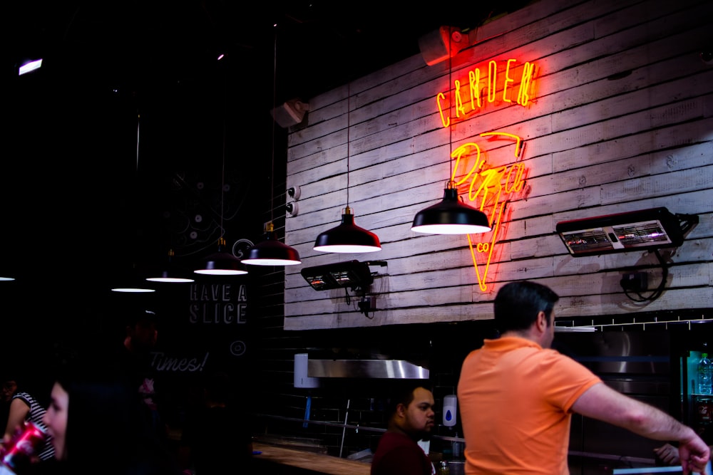 man standing near table near another man sitting inside restaurant