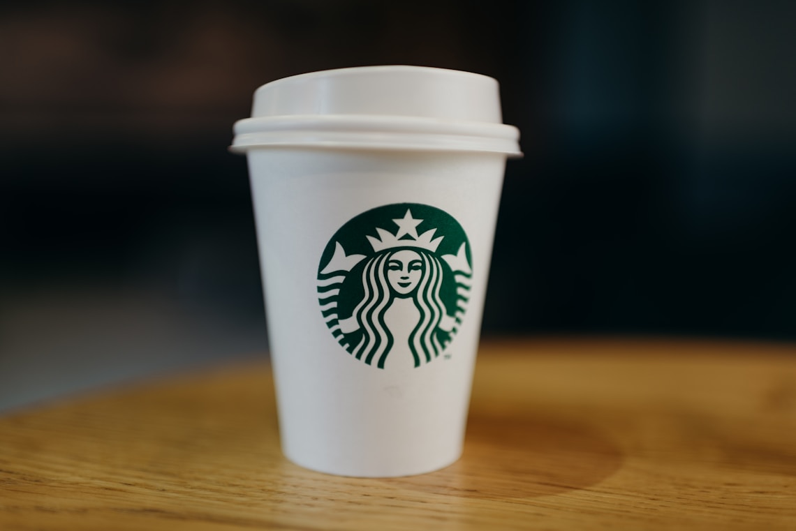 White Starbucks disposable cup on wooden table