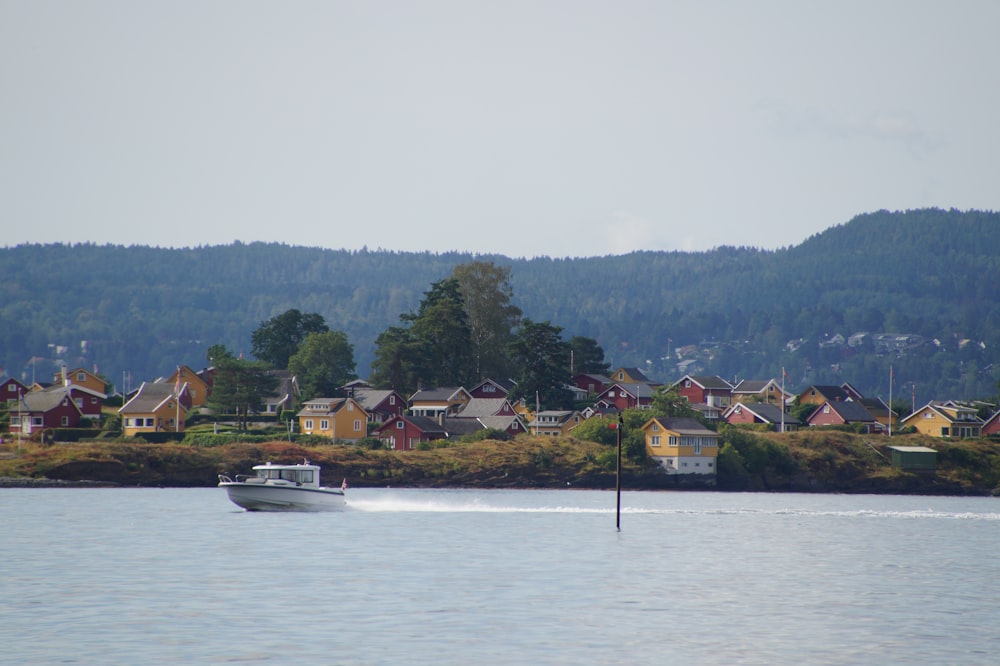 white speed boat near houses during daytime