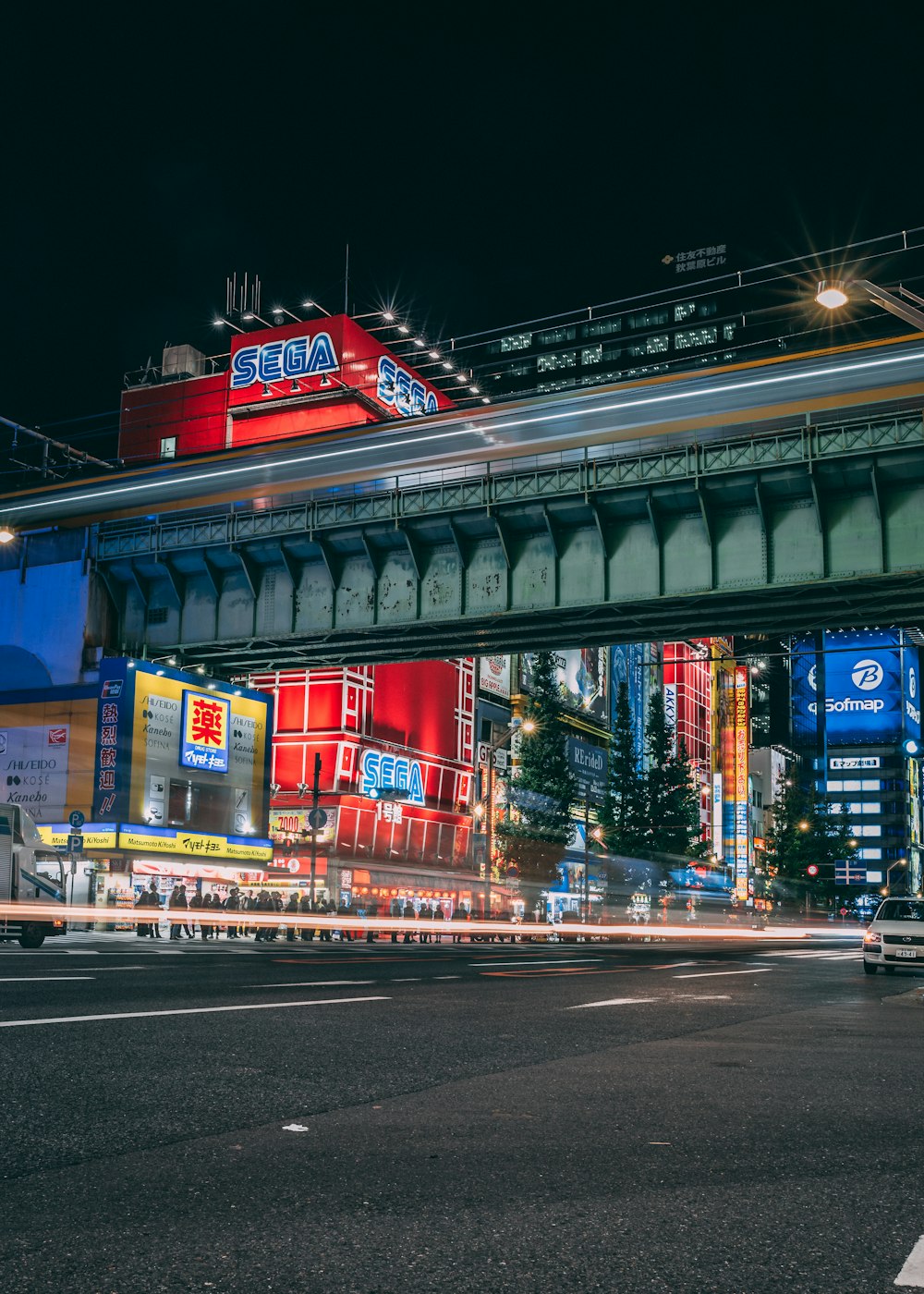 a city street at night with a bridge over it