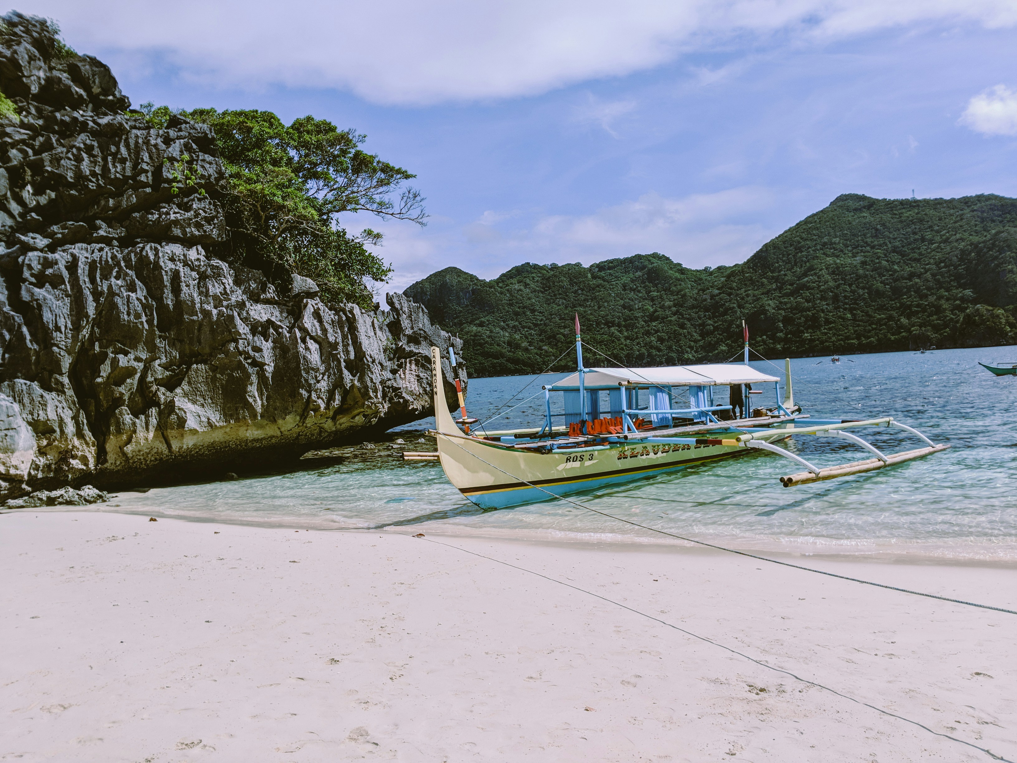 Crystal clear turquoise waters with traditional Filipino bangka boats, perfect for island hopping and snorkeling adventures