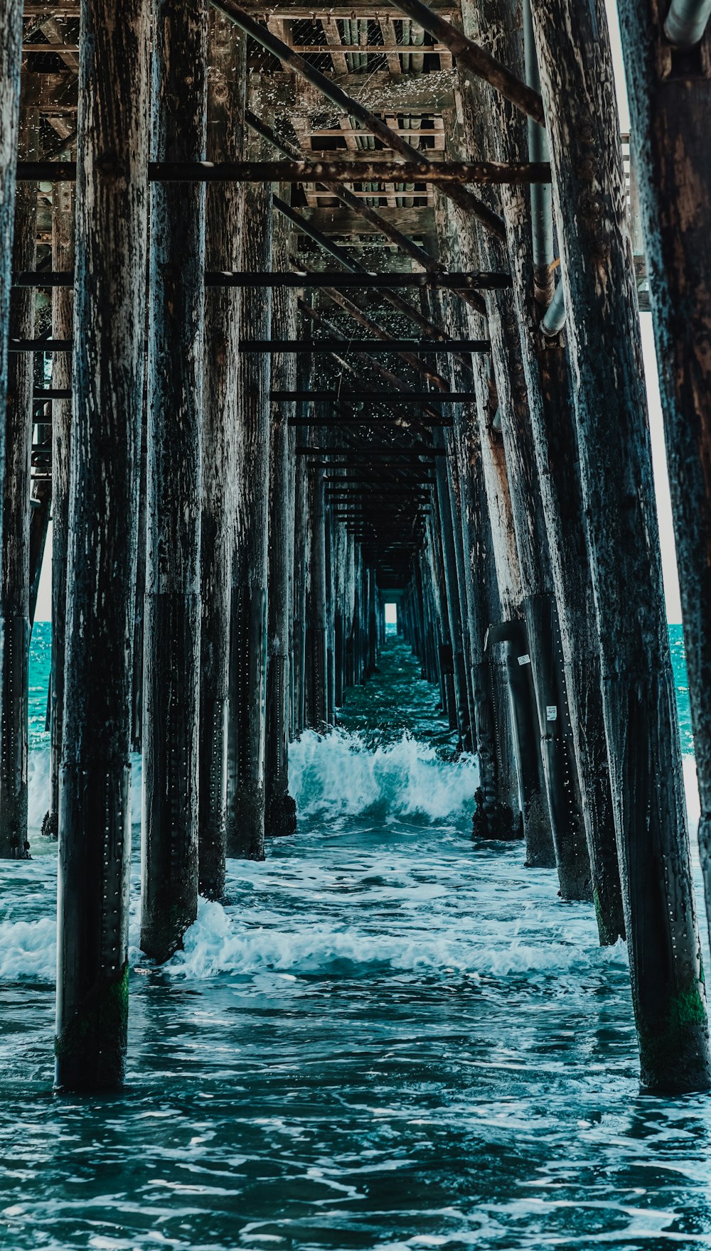 a view of the ocean under a pier