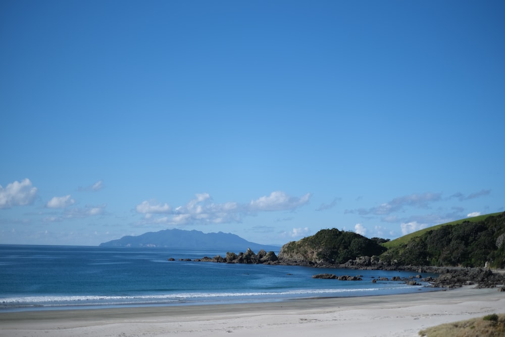 sea viewing mountain under blue and white skies