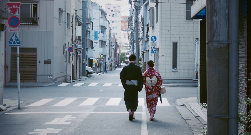 two people walking beside buildings