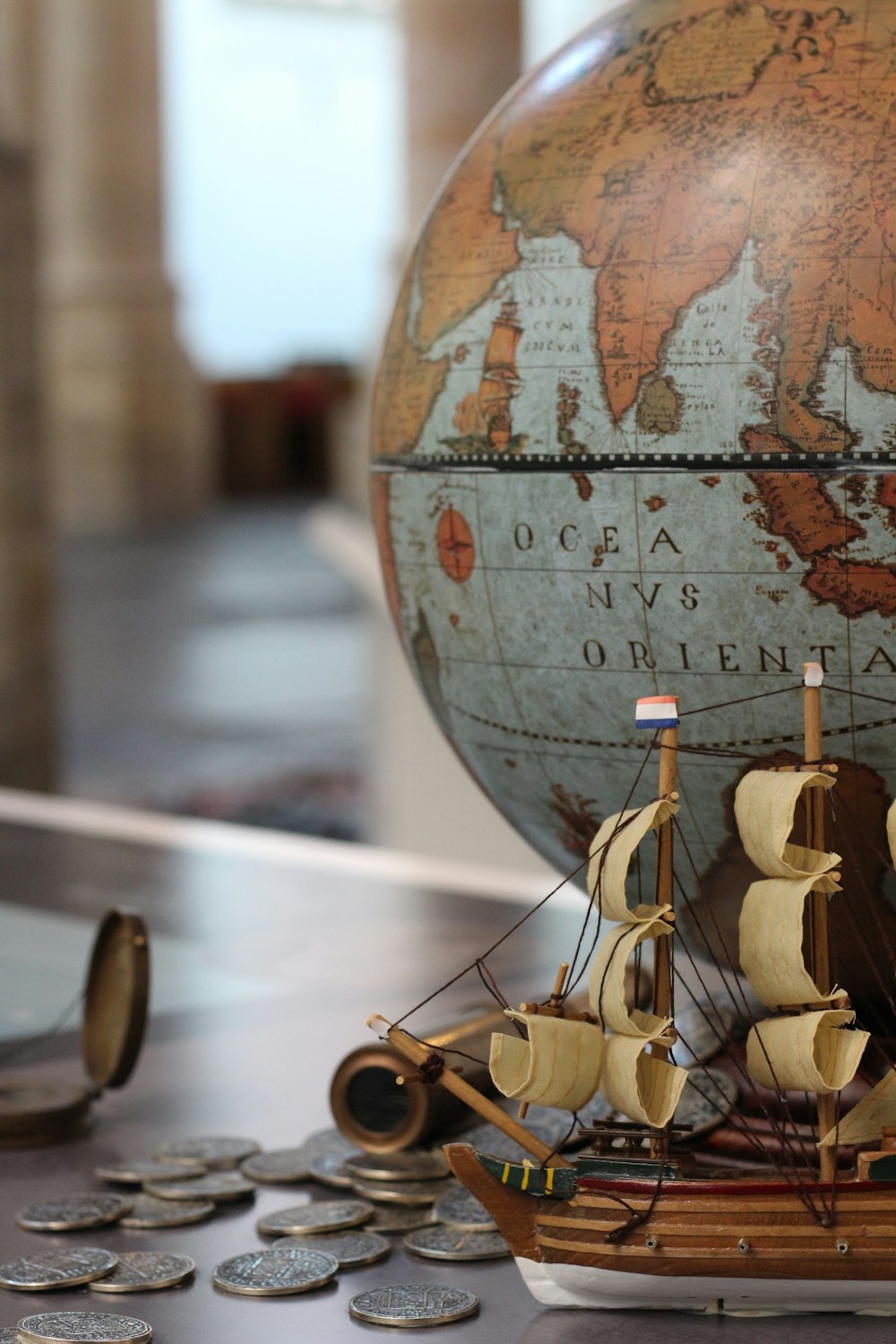 coins near galleon ship decor and desk globe