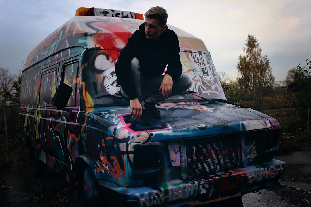 man squatting on top of van