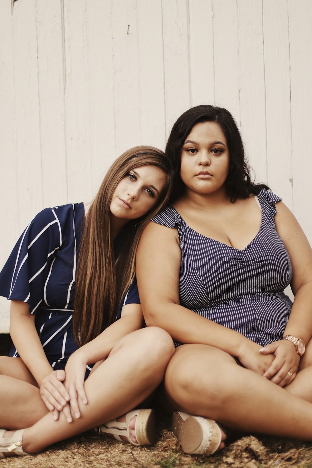 two women sitting on ground