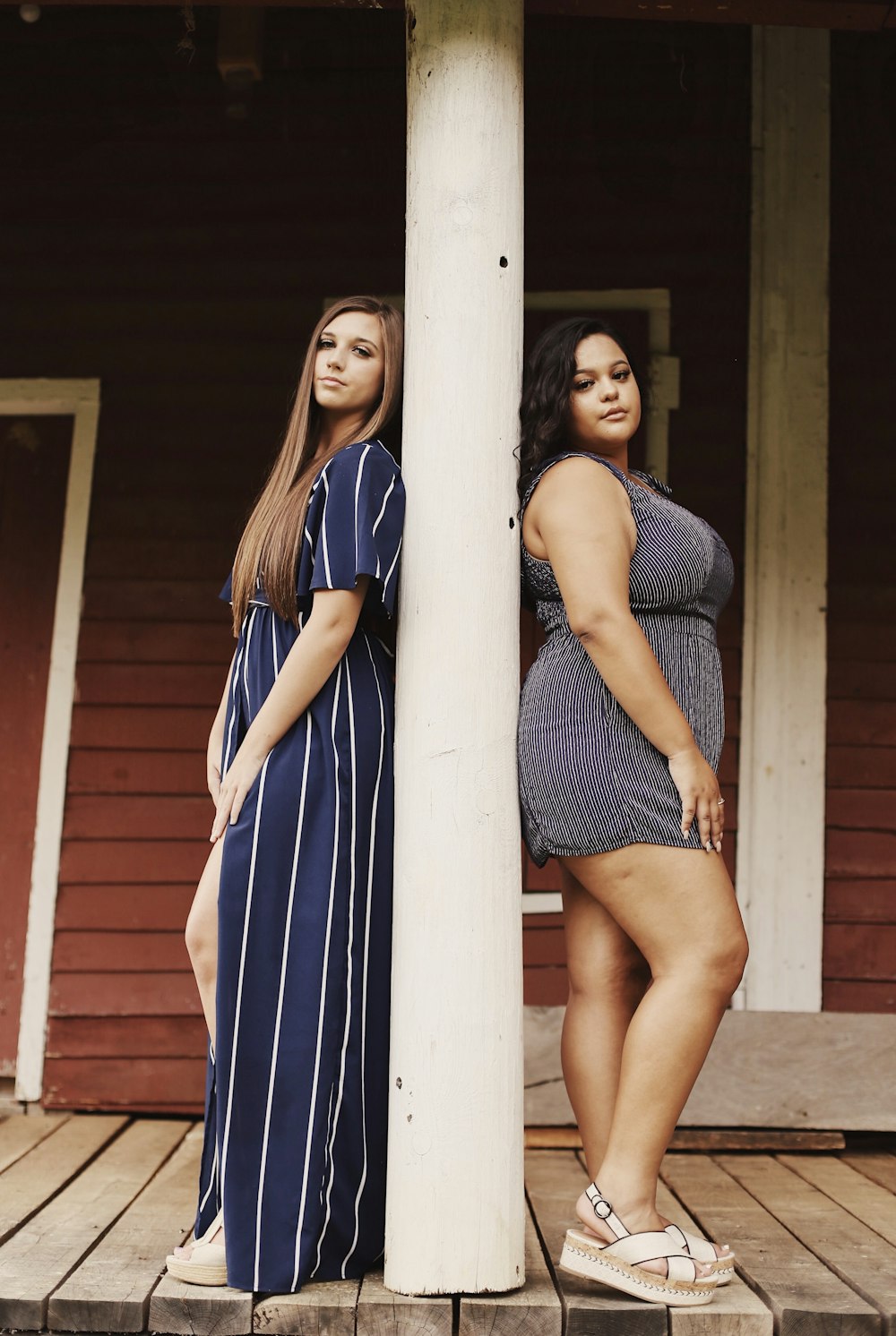 two women leaning on wall